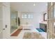 Bright bathroom with a glass-enclosed shower, soaking tub, and carrara marble at 340 President St, Charleston, SC 29403