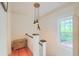 Bright hallway featuring hardwood floors, classic white trim, statement lighting and a charming window with a view at 340 President St, Charleston, SC 29403