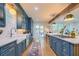 Well-lit kitchen with a large island, stainless appliances, and blue cabinets. French doors lead to the outside at 340 President St, Charleston, SC 29403