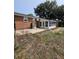Exterior view of the back of the house with patio, sunroom, and lush greenery at 4029 Karen Dr, North Charleston, SC 29405
