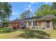 Spacious backyard with a red brick home, patio area, grill, and lush lawn under a blue sky at 411 Dogwood Circle, Summerville, SC 29485