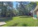 Large, grassy backyard featuring chairs, a grill, and large trees at 411 Dogwood Circle, Summerville, SC 29485