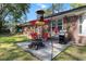 Backyard patio with a fire pit, dining set under an umbrella, grill and bird feeder at 411 Dogwood Circle, Summerville, SC 29485