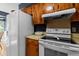 This kitchen features wood cabinetry, a white refrigerator and stove, and tan countertops at 411 Dogwood Circle, Summerville, SC 29485