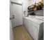 Bright laundry room with washer, dryer, storage shelves, and tile flooring; convenient and functional at 411 Dogwood Circle, Summerville, SC 29485