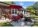 Brick home's patio with a red umbrella, dining set, grill, and fire pit, perfect for outdoor gatherings at 411 Dogwood Circle, Summerville, SC 29485
