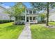 Charming two-story home featuring a manicured lawn, front porch and mature trees enhancing its curb appeal at 414 Hamlet Cir, Goose Creek, SC 29445