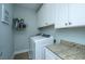 Functional laundry room featuring a modern washer and dryer, granite counters, and ample cabinet space at 414 Hamlet Cir, Goose Creek, SC 29445