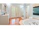 Bright bathroom featuring a soaking tub, double vanity, and a glass-enclosed shower with natural light at 43 Surfsong Rd, Kiawah Island, SC 29455