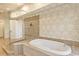A luxurious bathroom features a standalone tub, glass enclosed shower and elegant wallpaper at 43 Surfsong Rd, Kiawah Island, SC 29455