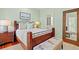 Charming bedroom featuring a dark wood bed, seahorse bench and a large, decorative mirror at 43 Surfsong Rd, Kiawah Island, SC 29455