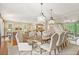 Open-concept dining room with wood floors, seating for eight, and direct access to the kitchen and living area at 43 Surfsong Rd, Kiawah Island, SC 29455