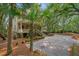 Charming two-story home with a large driveway and inviting front porch, surrounded by mature trees and landscaping at 43 Surfsong Rd, Kiawah Island, SC 29455
