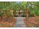 Beautiful two-story home with classic architecture, a manicured lawn, and lush trees creating a private, park-like setting at 43 Surfsong Rd, Kiawah Island, SC 29455