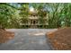 Stately two-story house with balconies, set back from the street and surrounded by trees at 43 Surfsong Rd, Kiawah Island, SC 29455