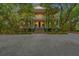 Stately three-story home with a classic design, featuring a grand entrance and surrounded by mature trees at 43 Surfsong Rd, Kiawah Island, SC 29455
