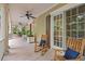Relaxing front porch with rocking chairs and ceiling fan, perfect for enjoying the outdoors at 43 Surfsong Rd, Kiawah Island, SC 29455