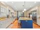 Well-lit kitchen featuring stainless steel appliances, an island with seating, and custom white cabinetry at 43 Surfsong Rd, Kiawah Island, SC 29455