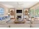 Well-lit living room showcasing a fireplace, built-in shelves, hardwood floors, and elegant decor, creating a cozy ambiance at 43 Surfsong Rd, Kiawah Island, SC 29455