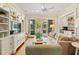 Stylish living room with built-in shelves, hardwood floors, a ceiling fan, and outdoor access at 43 Surfsong Rd, Kiawah Island, SC 29455