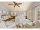 The bright main bedroom has wood floors, a ceiling fan, plenty of seating, and natural light at 43 Surfsong Rd, Kiawah Island, SC 29455