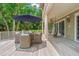 Outdoor patio with umbrella-covered table and seating, hanging chairs, and beautiful backyard at 43 Surfsong Rd, Kiawah Island, SC 29455