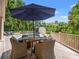 Outdoor dining area on wooden deck, complete with umbrella-covered table and seating, overlooks backyard at 43 Surfsong Rd, Kiawah Island, SC 29455