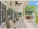 Relaxing covered porch with hanging swing chairs and views of the backyard and outdoor dining area at 43 Surfsong Rd, Kiawah Island, SC 29455