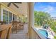 Inviting covered porch with wood floors and outdoor dining area overlooking a private pool at 43 Surfsong Rd, Kiawah Island, SC 29455