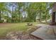 Large backyard featuring mature trees, grassy lawn, and a small concrete seating area at 436 Fox Hunt Rd, Goose Creek, SC 29445
