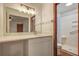 Bright bathroom features a white vanity with a white countertop, large mirror, and shower behind a wood-trimmed doorway at 436 Fox Hunt Rd, Goose Creek, SC 29445