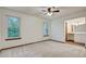 Inviting bedroom featuring carpeted floors, two windows with backyard view, and ensuite bath at 436 Fox Hunt Rd, Goose Creek, SC 29445