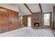 Spacious living room featuring a brick fireplace, wood beams, and wood paneling for a rustic yet cozy appeal at 436 Fox Hunt Rd, Goose Creek, SC 29445