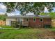 A backyard features a brick home with a wooden deck, complemented by a lush green lawn and mature trees at 444 Clarine Dr, Goose Creek, SC 29445
