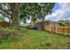 The large backyard features a brick home, wooden fence, and a storage shed, all nestled under a beautiful, mature tree at 444 Clarine Dr, Goose Creek, SC 29445