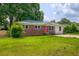 Charming home showcases a brick facade, a well-kept lawn, and a welcoming red door, creating a warm and inviting feel at 444 Clarine Dr, Goose Creek, SC 29445