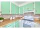 Galley kitchen featuring vintage mint green cabinets and clean white appliances at 444 Clarine Dr, Goose Creek, SC 29445