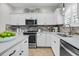 Well-appointed kitchen with white cabinets, stainless steel appliances, and stylish brick backsplash at 448 Jardinere Walk, Mount Pleasant, SC 29464