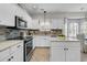 Well-lit kitchen featuring white cabinets, stainless steel appliances, and tile flooring at 448 Jardinere Walk, Mount Pleasant, SC 29464