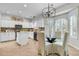 Bright eat-in kitchen with white cabinets, stainless steel appliances, island and modern chandelier at 448 Jardinere Walk, Mount Pleasant, SC 29464
