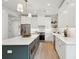 Modern kitchen showcasing white cabinets, stainless steel appliances, an island with seating, and stylish lighting at 4620 O'Hear Ave, North Charleston, SC 29405