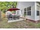 Outdoor dining area with a table, chairs, red umbrella, and grill create a welcoming space for backyard gatherings at 469 Hainsworth Dr, Charleston, SC 29414