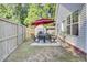 Outdoor dining area with a table, chairs, red umbrella, and grill create a welcoming space for backyard gatherings at 469 Hainsworth Dr, Charleston, SC 29414