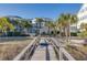 A wooden walkway leads to a condominium resort with palm trees and landscaping at 509 Summerhouse, Isle of Palms, SC 29451