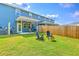 Spacious backyard featuring a well-maintained lawn, patio area, fire pit, and privacy fence at 5135 Park Creek Ave, North Charleston, SC 29418