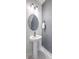 Elegant powder room with a pedestal sink, round mirror, stylish fixture and a towel rack at 5135 Park Creek Ave, North Charleston, SC 29418