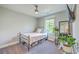Cozy bedroom featuring a metal bed frame, neutral walls, a ceiling fan, and a window offering natural light at 5135 Park Creek Ave, North Charleston, SC 29418