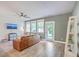 Spacious living room showcasing wood floors, rear access door, bright windows and a ceiling fan at 5135 Park Creek Ave, North Charleston, SC 29418