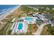 Stunning aerial view of oceanfront community with pools, beach access, and lush landscaping at 6002 Green Dolphin Way, Kiawah Island, SC 29455