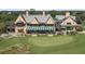 Expansive estate home on a golf course with awnings and manicured lawn at 6002 Green Dolphin Way, Kiawah Island, SC 29455